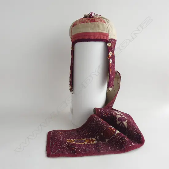 A Turkmen Kyrgyz ceremonial long tail hat, (chach kep) with long embroidered tail and mother-of-pearl buttons…